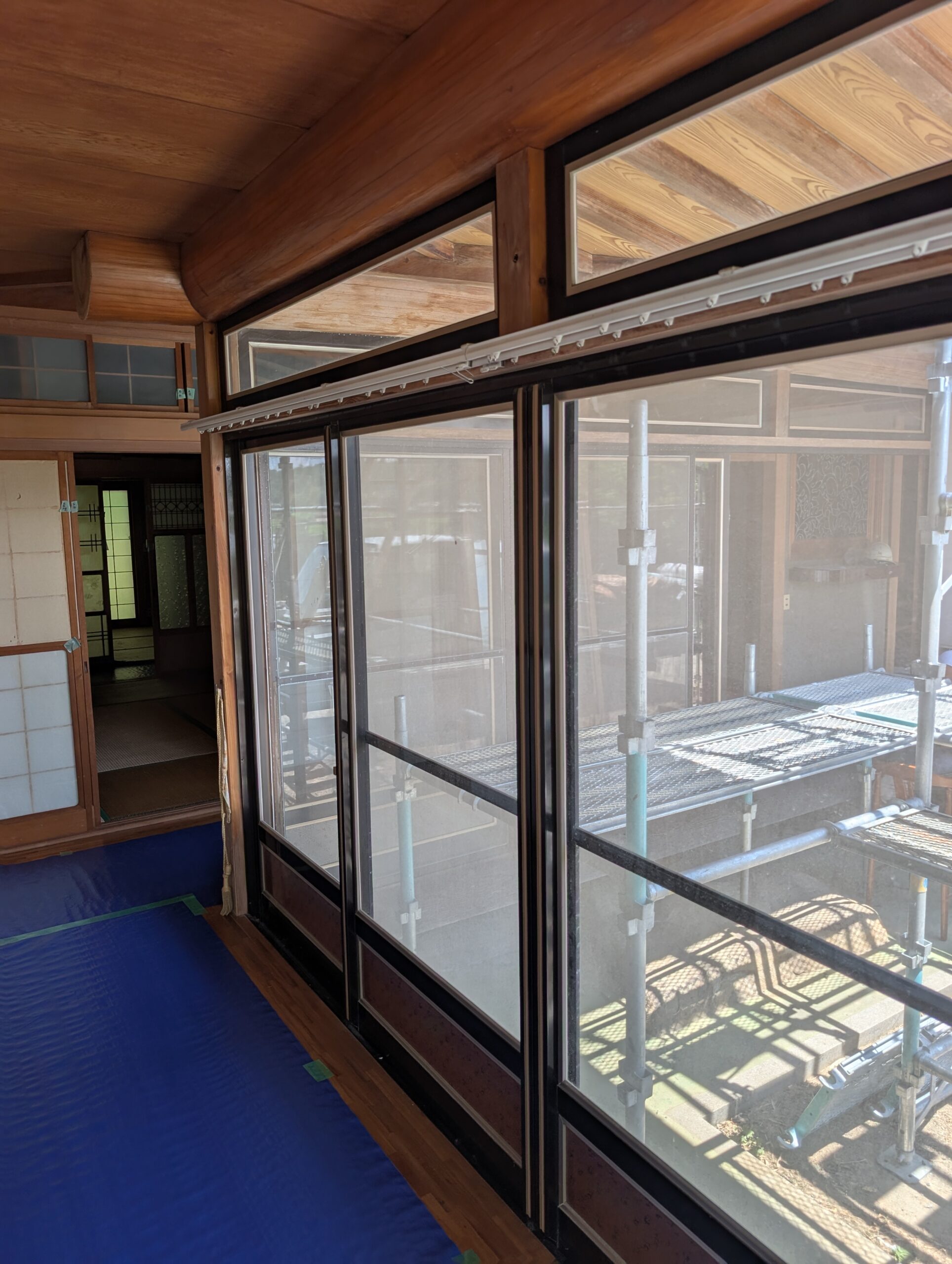 リノベーション前のアルミサッシ窓。外に足場が見え、奥には障子の建具が並ぶ